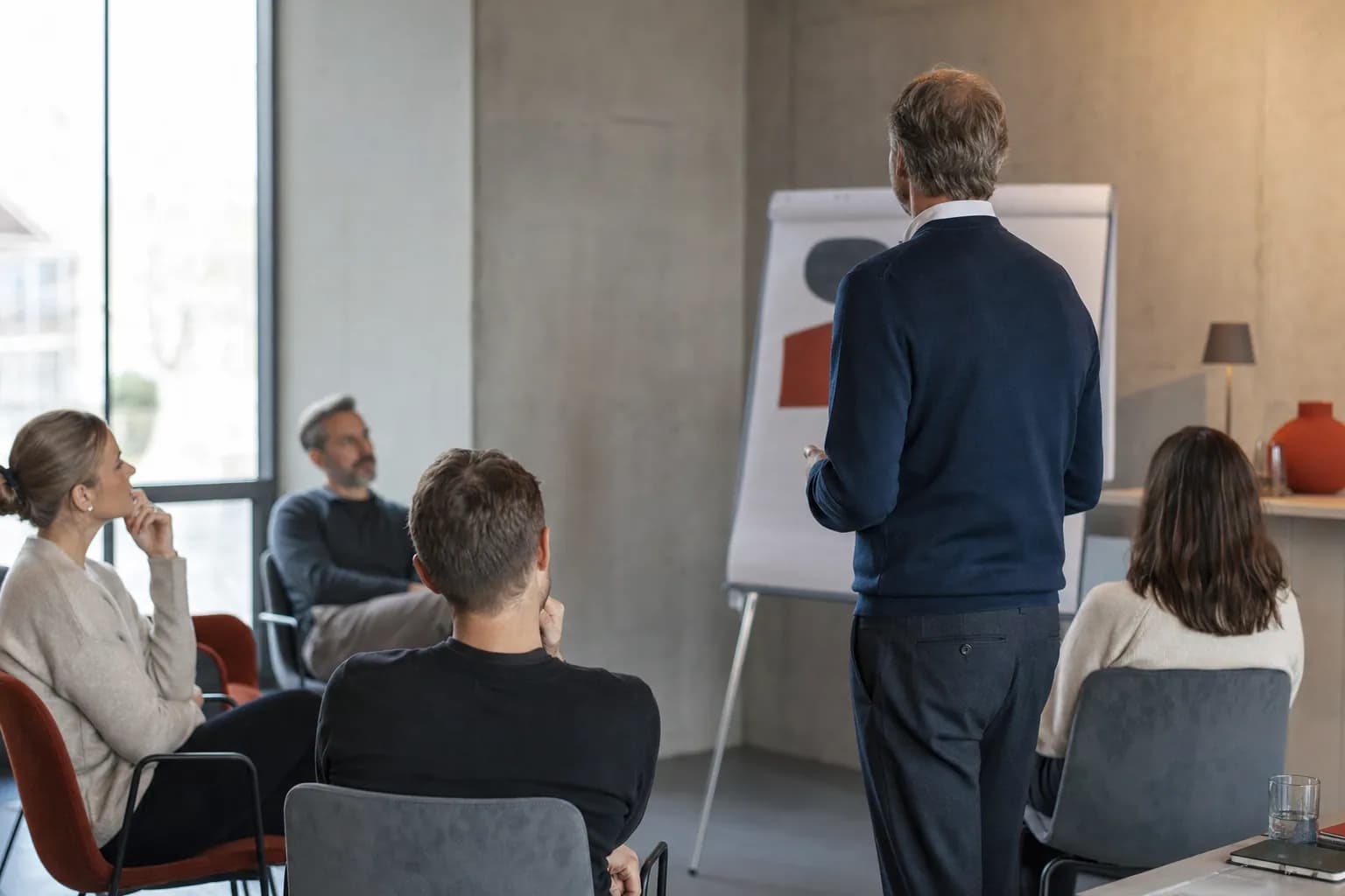 Kleiner Workshop mit vier Teilnehmenden und einer Moderation am Flipchart.