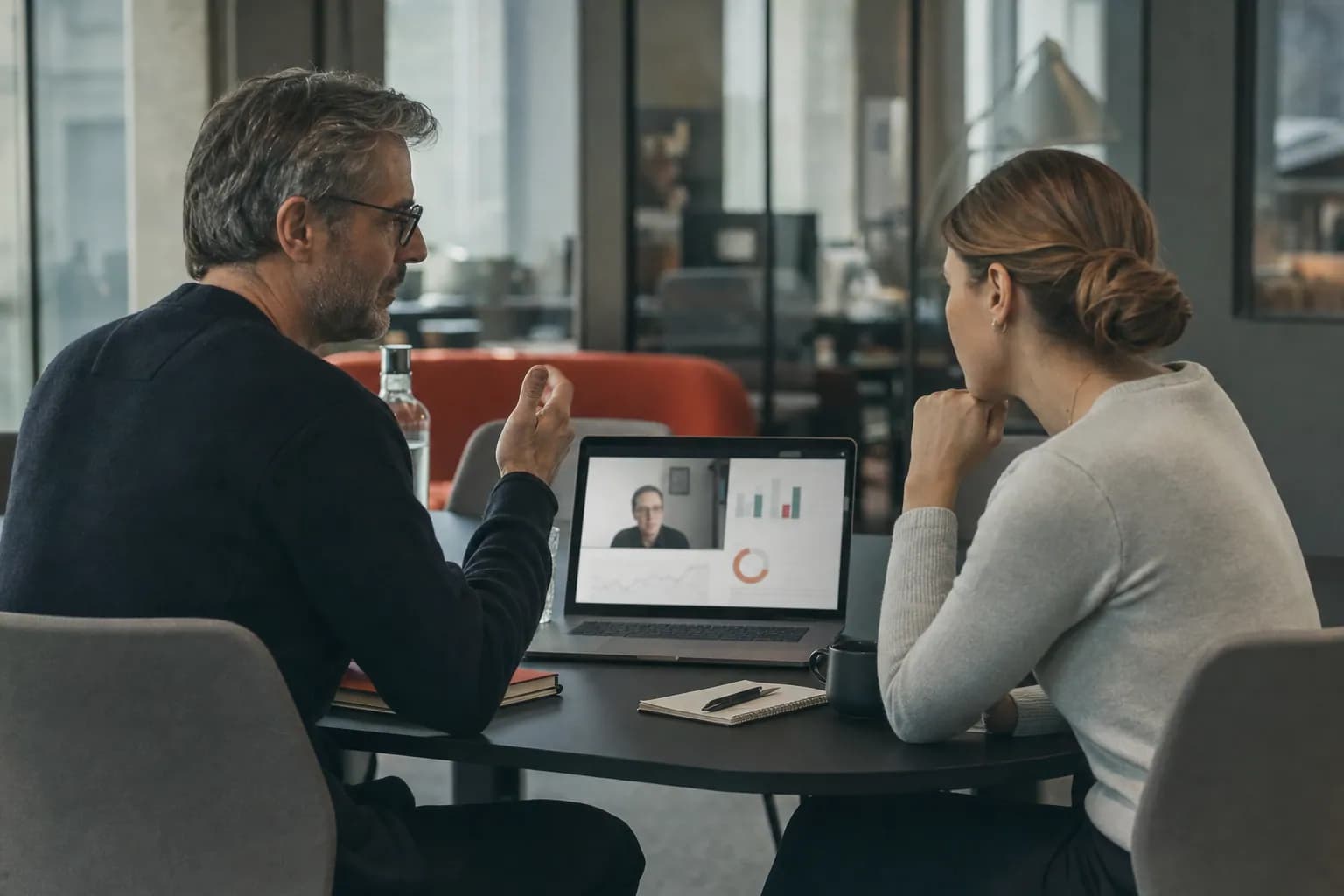 Zwei Personen am Besprechungstisch eines Softwareunternehmens im Video-Call mit einem Kunden.